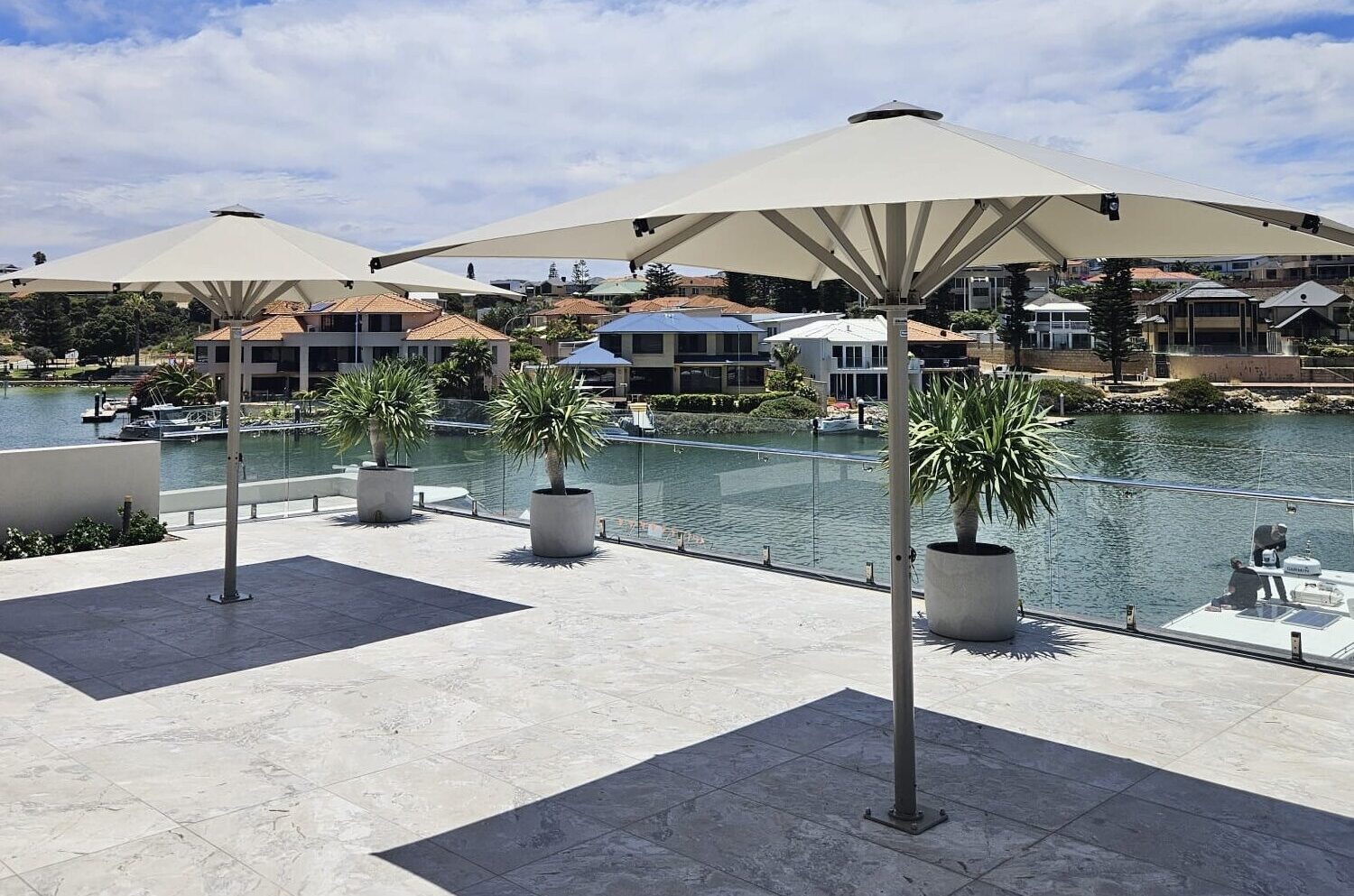 Commercial umbrella shading an outdoor seating area by the water