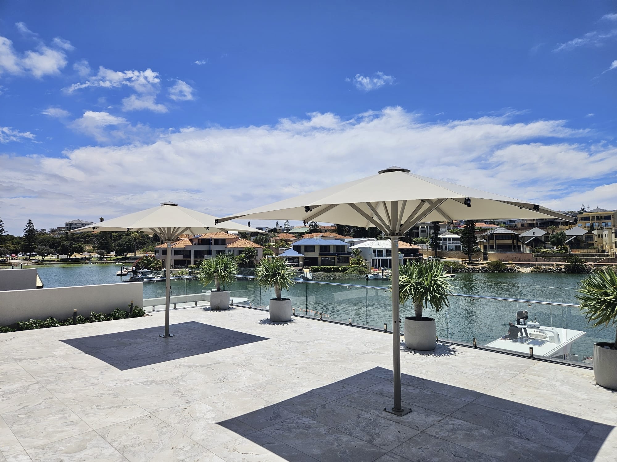 Ultrashade umbrella shading an outdoor seating area by the water