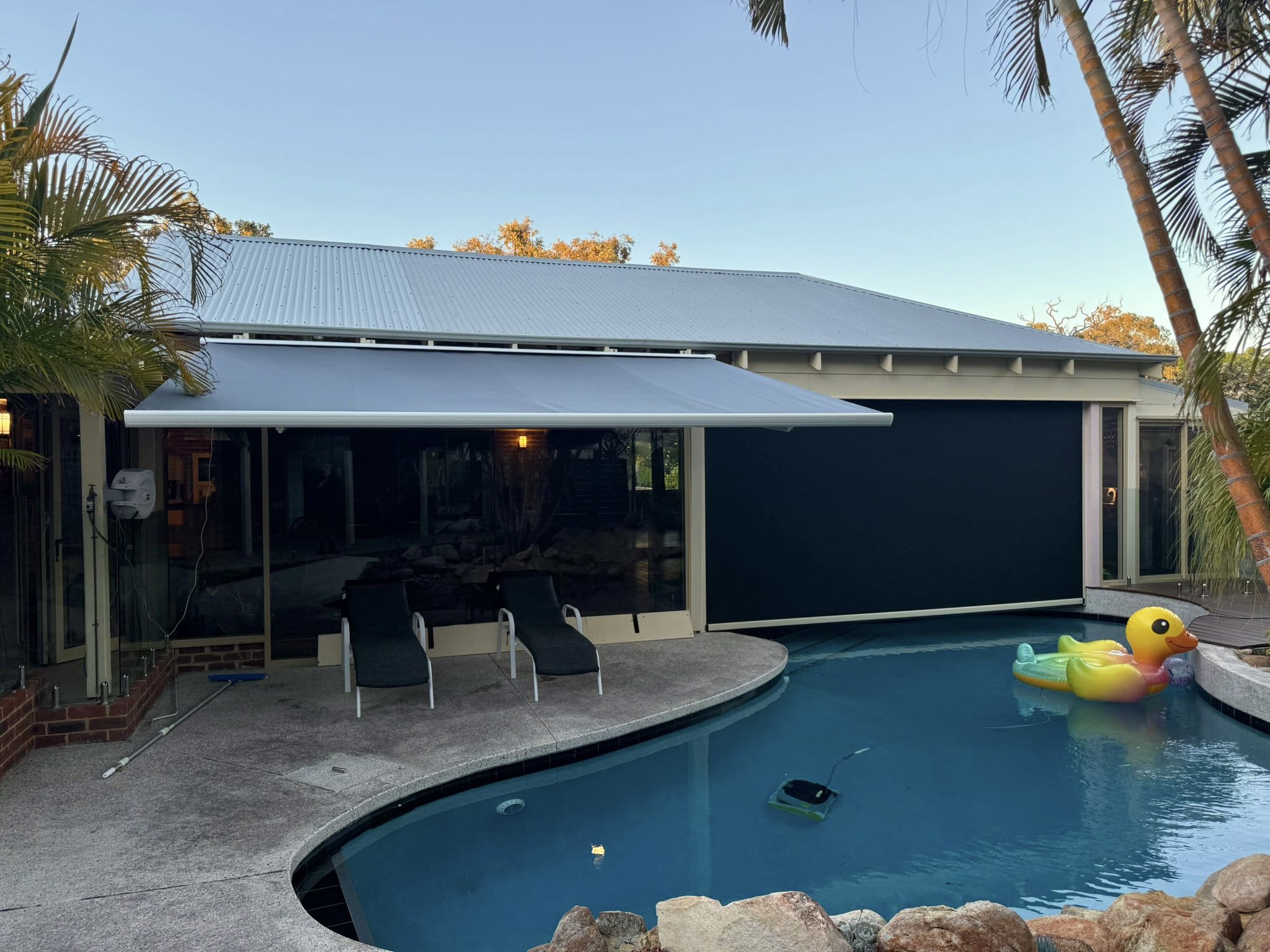 Outdoor blinds installed on a Perth patio beside a pool