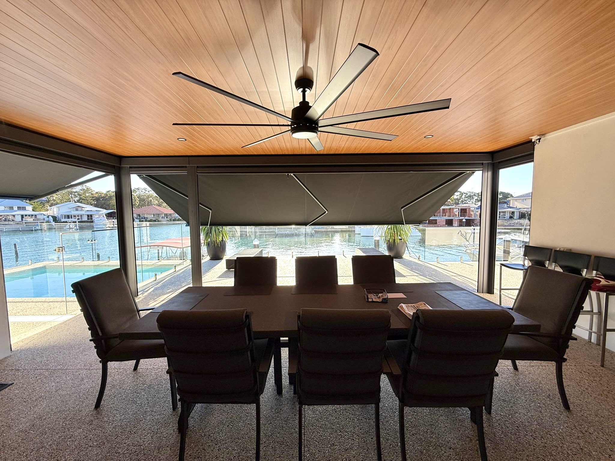  Retractable folding arm awning in a waterfront alfresco dining area