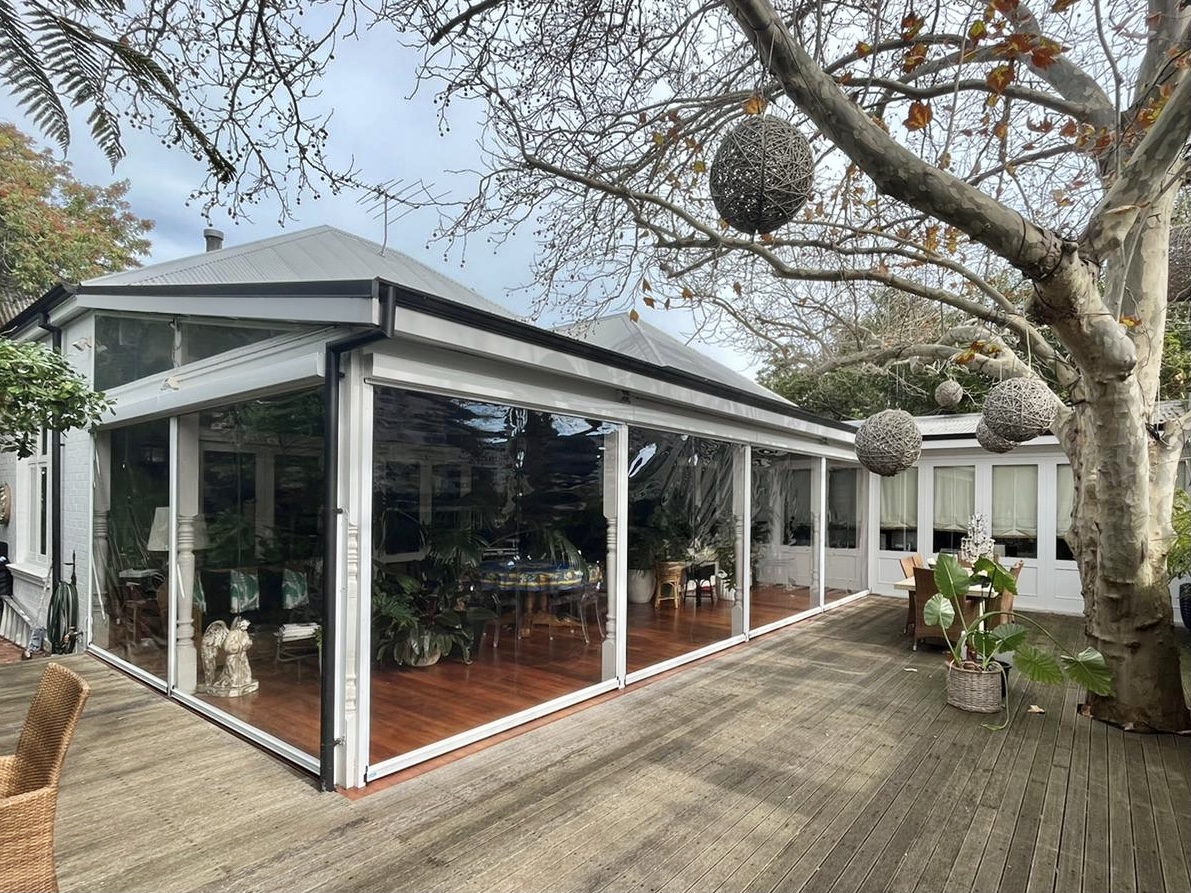 Clear PVC outdoor blinds fully enclosing a patio for winter weather protection